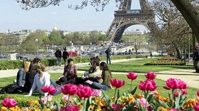 Students sitting on the grass near the Eiffel Tower
