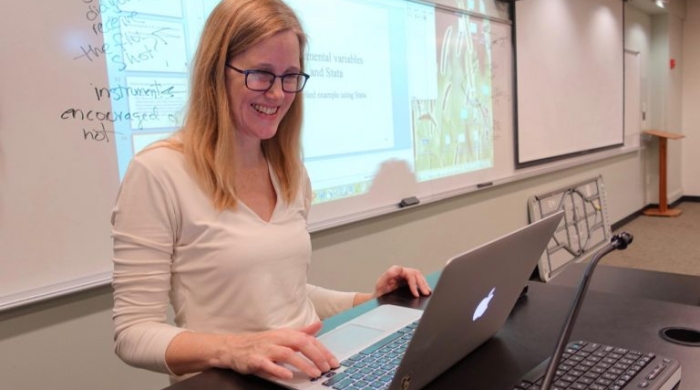 NYU Professor Jennifer Hill in her classroom on her laptop.