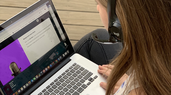A student participating in the Voice Drive using a headset and laptop.