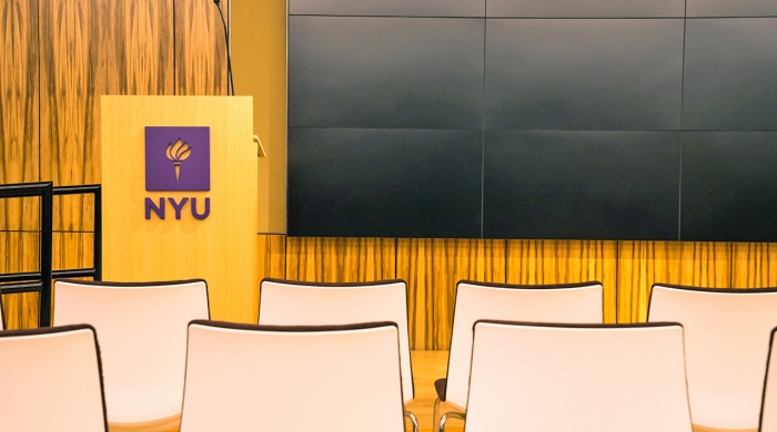 Rows of seats in front of a lecturn labelled with NYU