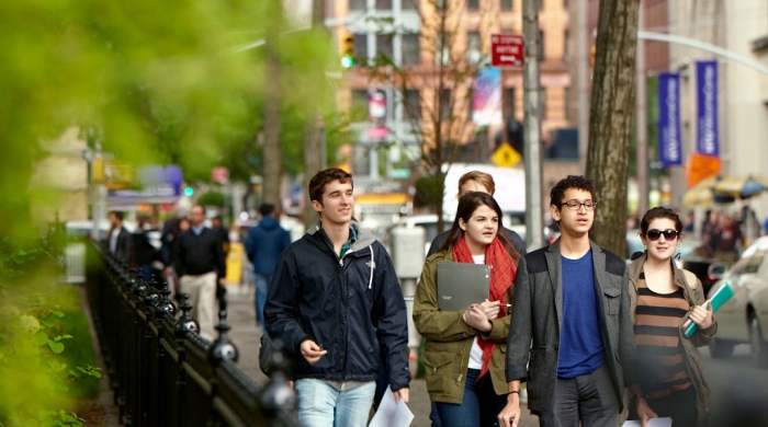 A group of undergrad students walk along Washington Square North