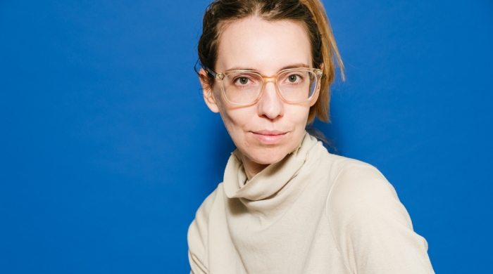 A professional photograph of Rachel Lifter in front of a blue background.