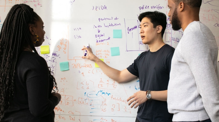 A group of applied statistics students working at a whiteboard