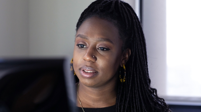 A Black woman working at a desktop computer