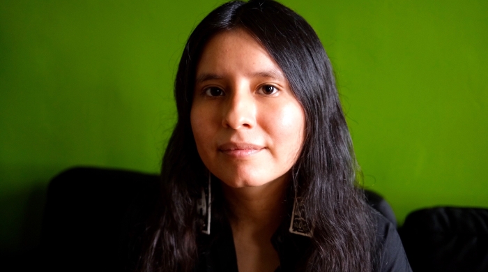 woman smiling on front of green wall