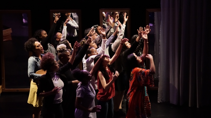group of performers with arms raised 