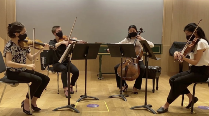 A string quartet performing remotely