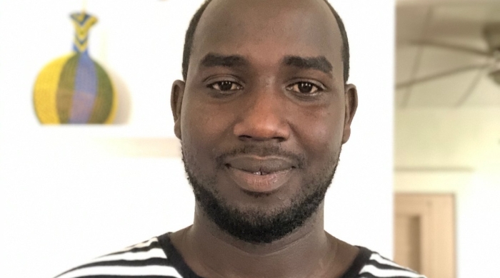Mondiant Dogon smiling in black and white striped shirt