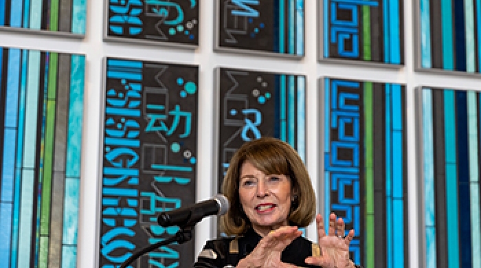 Professor Marion Moffat stands at podium at dedication ceremony