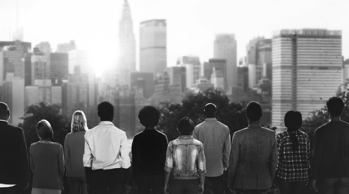 Black and white photo of people looking at the skyline.