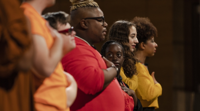 people standing in a row with hands on the chests 