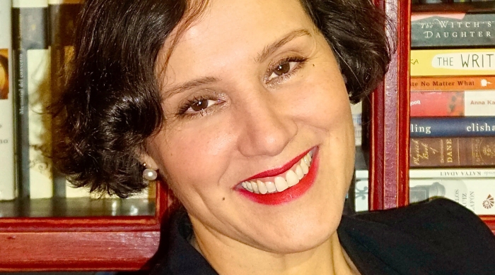 A headshot of Dr. Gigliana Melzi in front of a bookcase