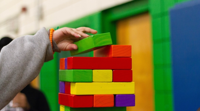 Child's hand stacking blocks.