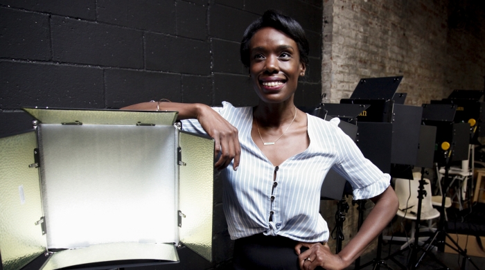 Kweighbaye Kotee leans against a studio light box