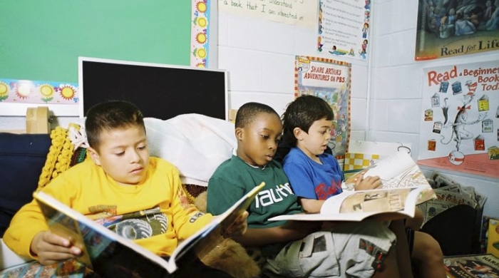 Primary school children reading in a classroom.