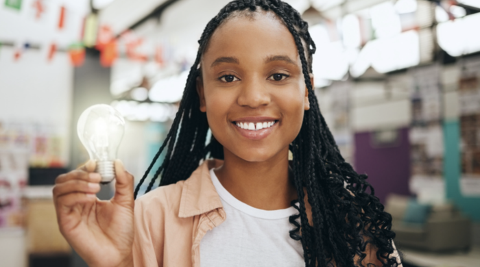 girl holding a bulb and smiling