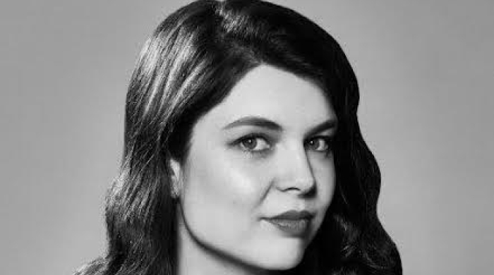 Black and white portrait of Sarah Bridgins. Shirt has black and white triangles. 