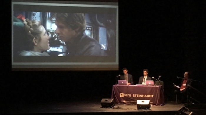 Star wars clip on screen with discussion in front of it being led by three faculty