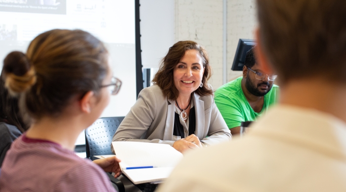 Professor Carol Anne Spreen smiling and facilitating a discussion with students