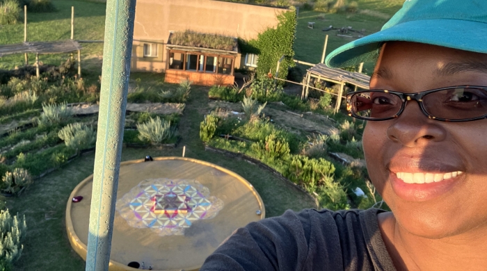 Selfie of Jillian with the "Flower of Life" in the background, the organization icon for Quinta Esencia, School of Sustainability 