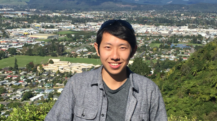 Photo of Tom Gao with a city and mountains in the background