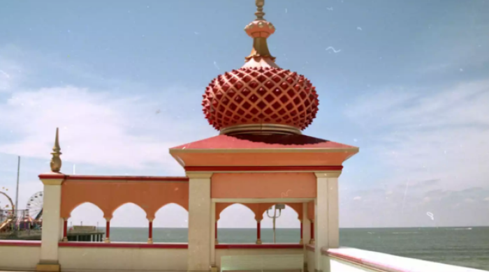 A photo of a decorative shade structure on a patio overlooking a body of water.