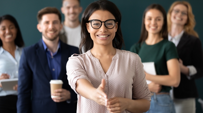 Woman in workplace extending welcoming hand