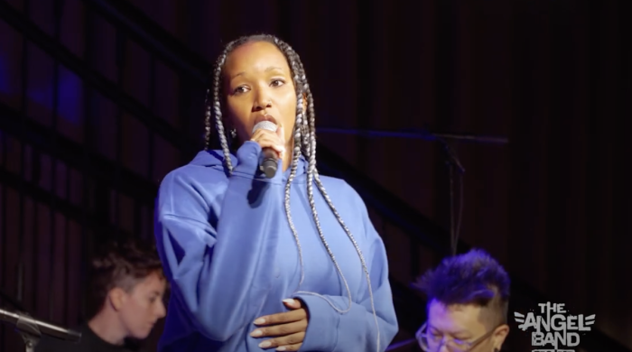 Woman on stage singing into microphone