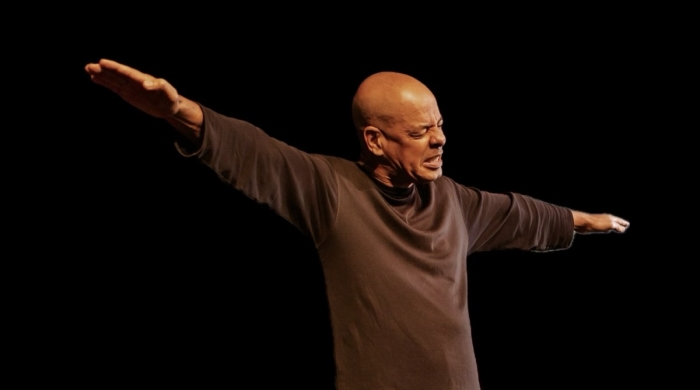 Performer on stage with arms stretched like an airplane