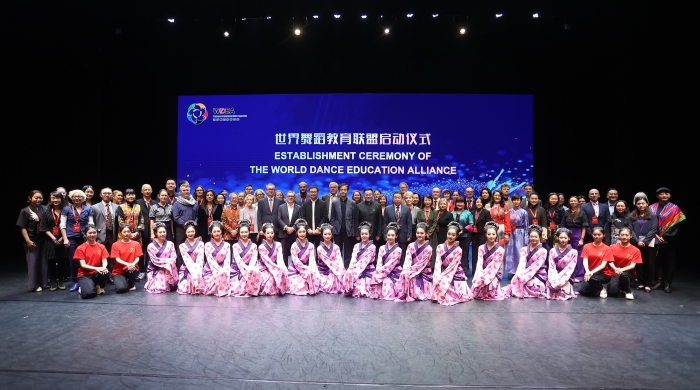 A large group of people in front of a screen that says, "Establishment Ceremony of the World Dance Education Alliance"