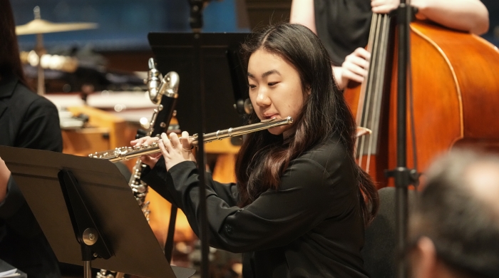 Student playing flute in orchestra