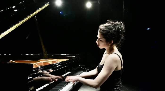 Piano student CiCi Fader playing a grand piano