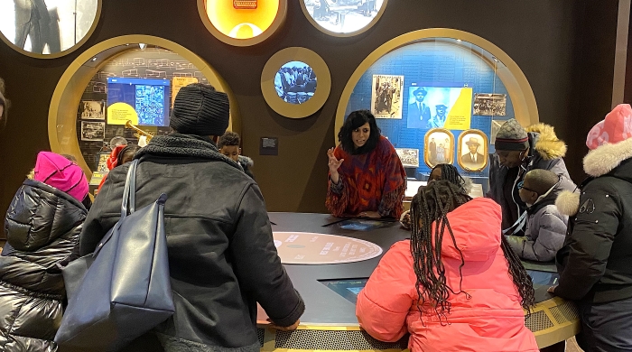 Charanya talks to students at a museum exhibit