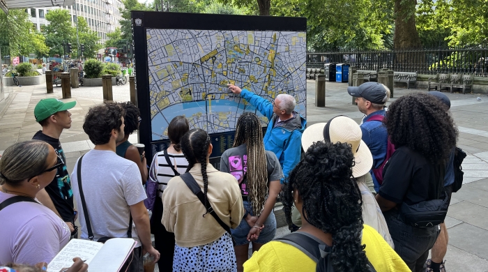 Students and an instructor gather around a city map