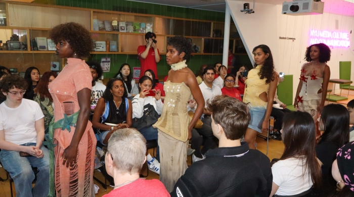 Four models stand amidst a crowd