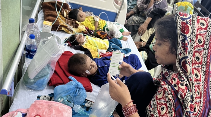 Babies lay on hospital beds while people attend to them