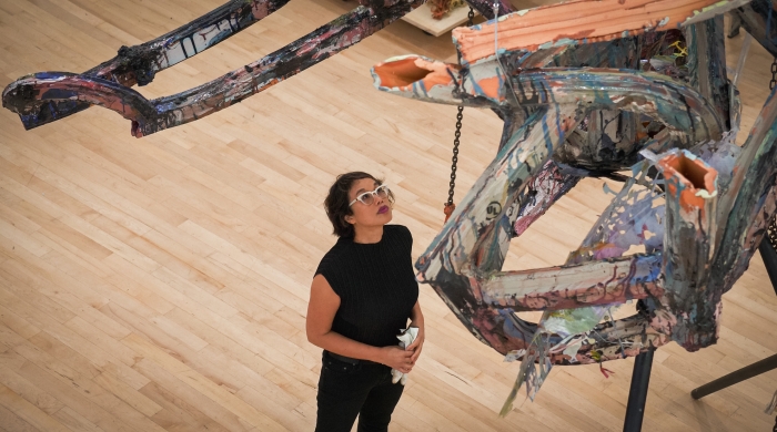 Linda standing underneath a multi colored suspended sculpture