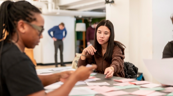 Students sitting at table studying index cards as a group