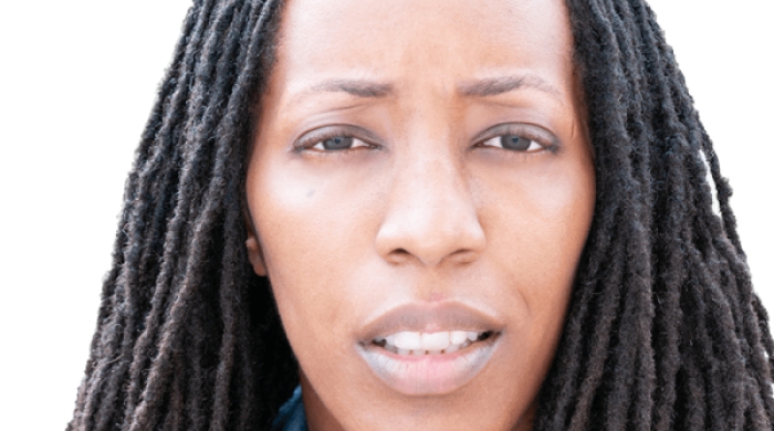Image captures a headshot of Dr. Bettina L. Love. The phoot captures the NYU Metro Center 2026 Keyunote Speakers against a white backgroun with shoulder length locks. Dr. Love whears a blue collareded denim shirt with a red sportcoat.