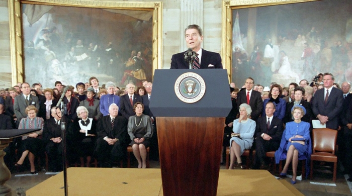President Reagan stands behind a podium inside the Capitol Rotunda for his 1985 inauguration