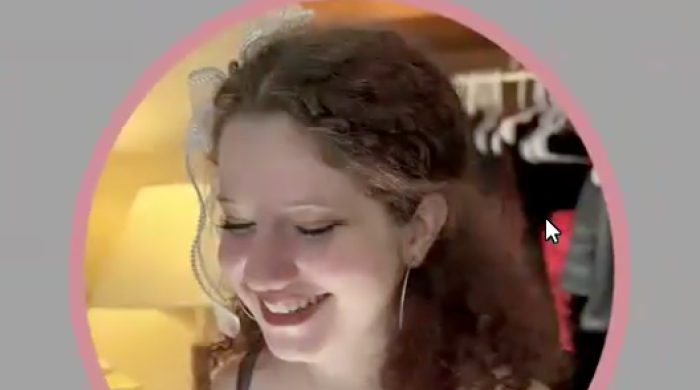 Image captures a headshot of Simona Freed.  Simona is the presenter of webinar for the nest Support Project. In tthe photo, Simona wears a green top and culry reddish