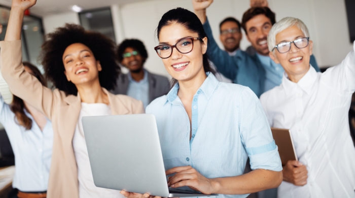 Photo of excited people, one holding a laptop