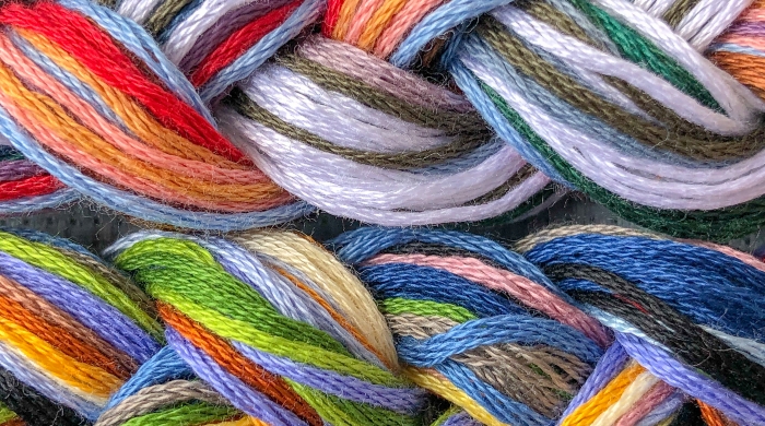 background of multi-colored threads of floss braided threads for embroidery