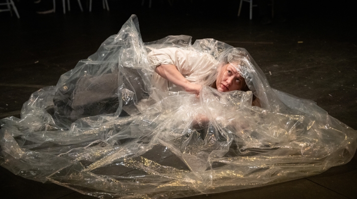 Student lying on floor covered in plastic