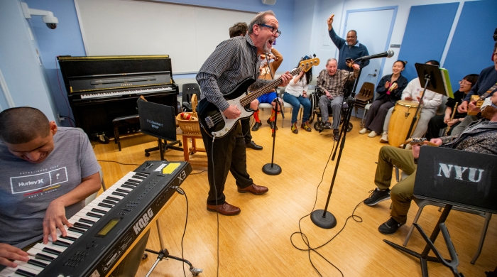 Alan Turry plays instruments with a crowd of people.