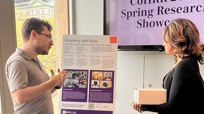 Student presenting a poster on 3D printing for assistive technology to showcase attendee