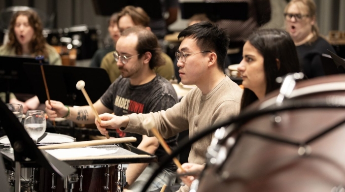 Students play percussion instruments.