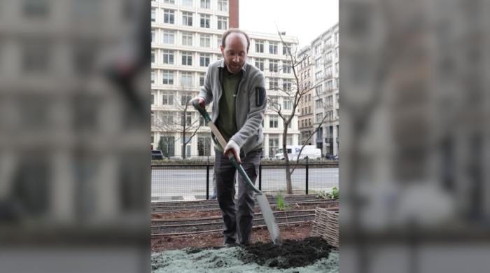 A photo of Professor Jonathan Lambert, outdoors, shoveling dirt