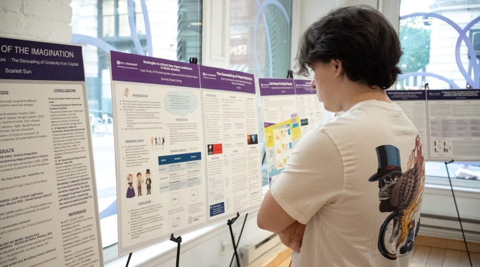 Student looking at research projects presented on easels