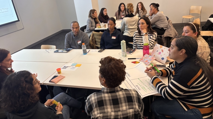 Workshop attendees gather around a table during a TISI training. 